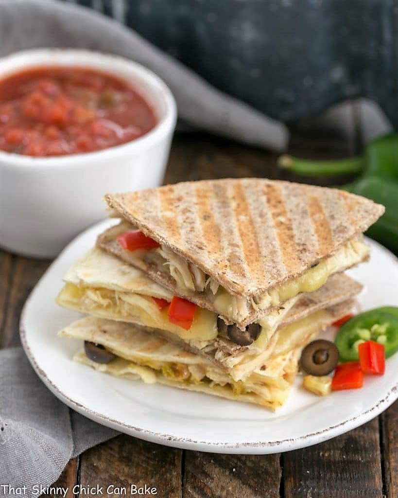 Cheesy Chipotle Chicken Quesadillas stacked on a round white plate