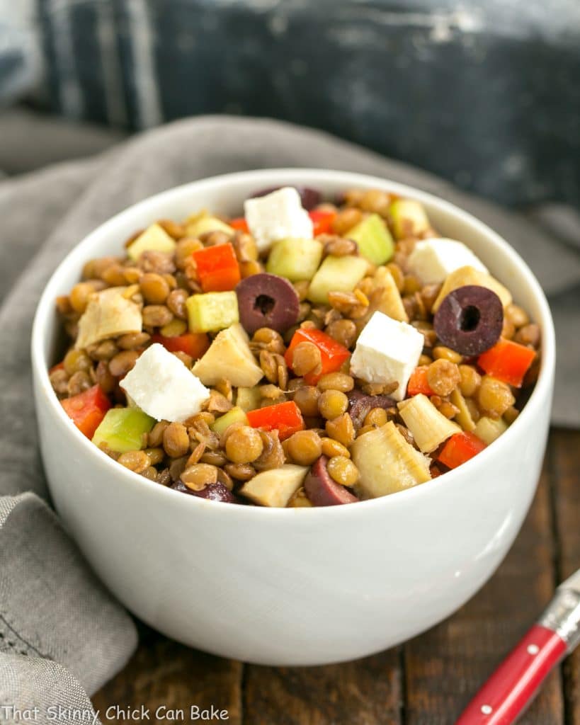Mediterranean French Lentil Salad healthy, hearty and full of fiber, diced vegetables, kalamata olives and feta Mediterranean French Lentil Salad in a white bowl with red handled spoon
