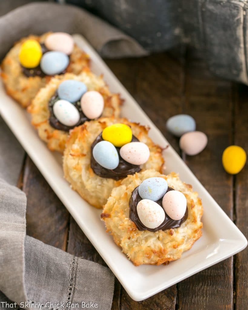 Coconut Macaroon Easter Nests lined up on a white ceramic tray