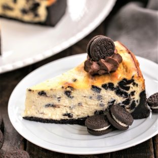 Slice of Oreo Cheesecake with Oreo Cookie Crust on a white plate