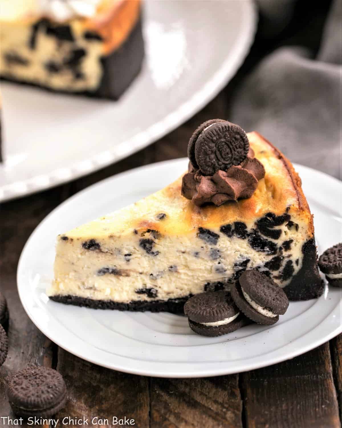 Slice of Oreo Cheesecake with Oreo Cookie Crust on a white plate.