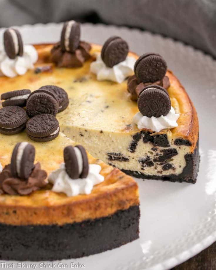 Oreo Cheesecake with Oreo Cookie Crust with slice gone on white serving plate