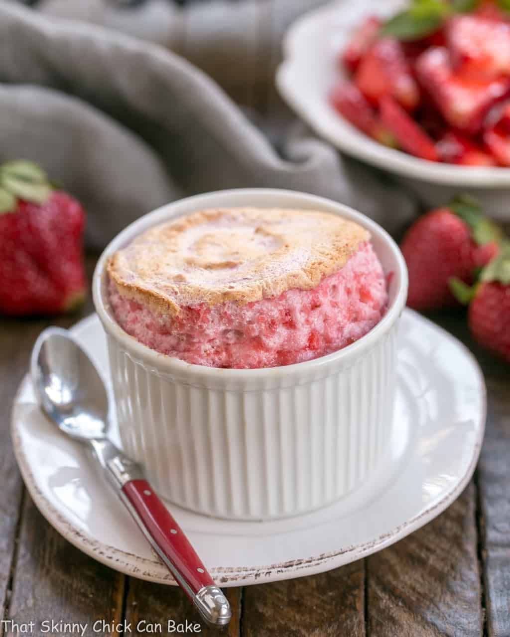 Strawberry Soufflé in a white ramekin with a red handled spoon.