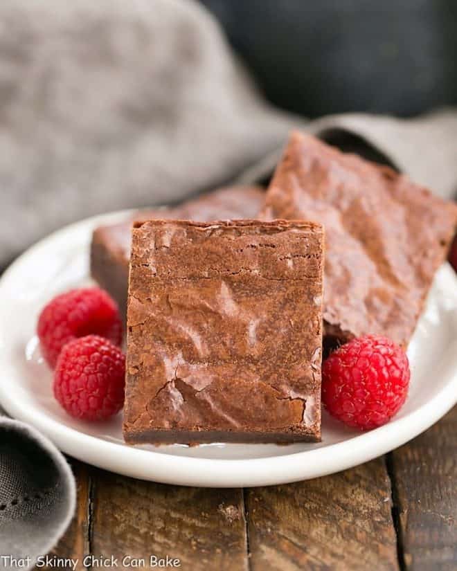 The best fudgy brownies on a white dessert plate.