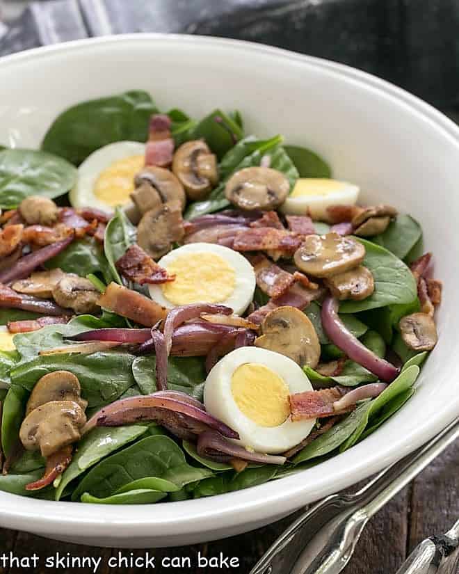 Best Spinach Salad close up in a white ceramic bowl.