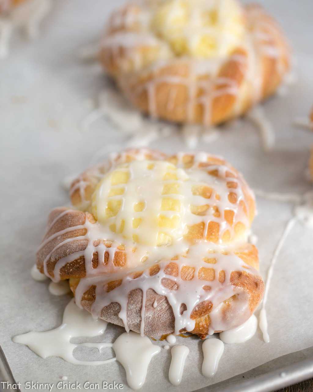 Danish Twists with Cream Cheese Filling - tender, sweet yeast bread twists with a luscious cream cheese filling Danish Twists with Cream Cheese Filling on a parchment lined sheet pan.