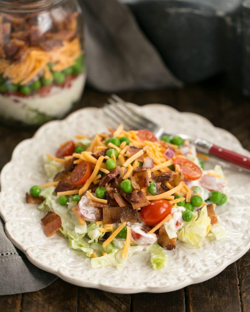 Make Ahead 7-Layer Salads in a Jar removed to a white salad plate