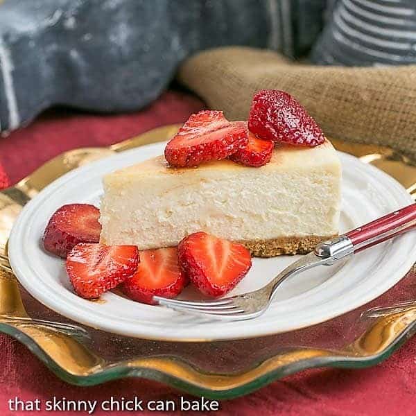 Mascarpone Cheesecake with Balsamic Strawberries on a white dessert plate with a red handled fork.