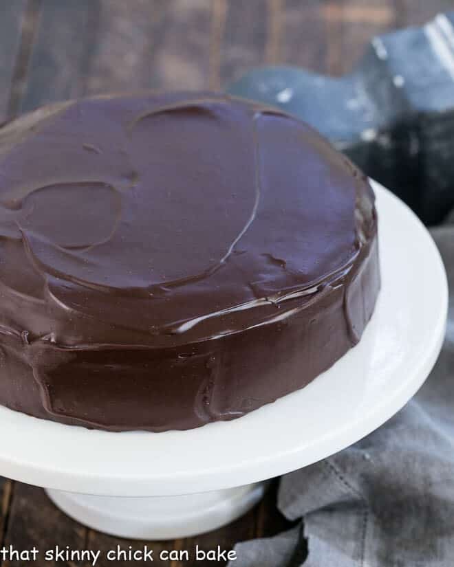 One Layer Fudge Cake on a white ceramic cake stand.