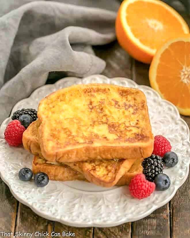 Grand Marnier French Toast stacked on a decorative plate with fresh berries.