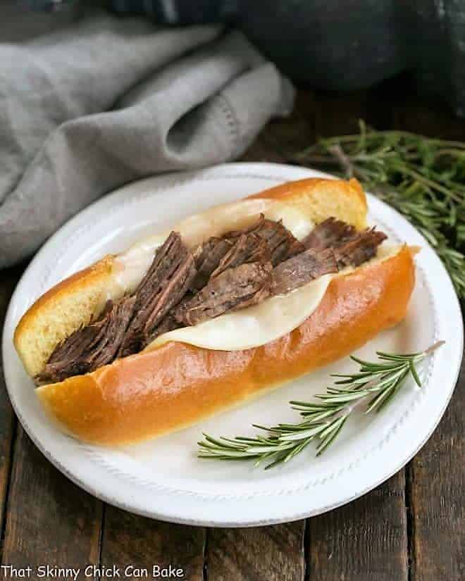 Instant Pot French Dip Sandwich on a white plate with a sprig of rosemary