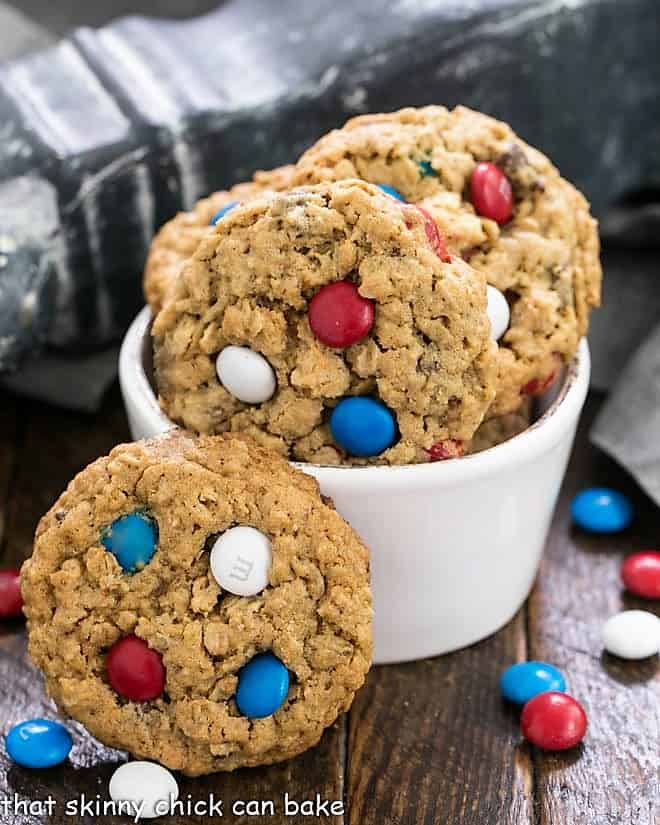 Peanut Butter Oatmeal Cookies with M&Ms in a small white bowl surrounded by patriotic colored M&Ms