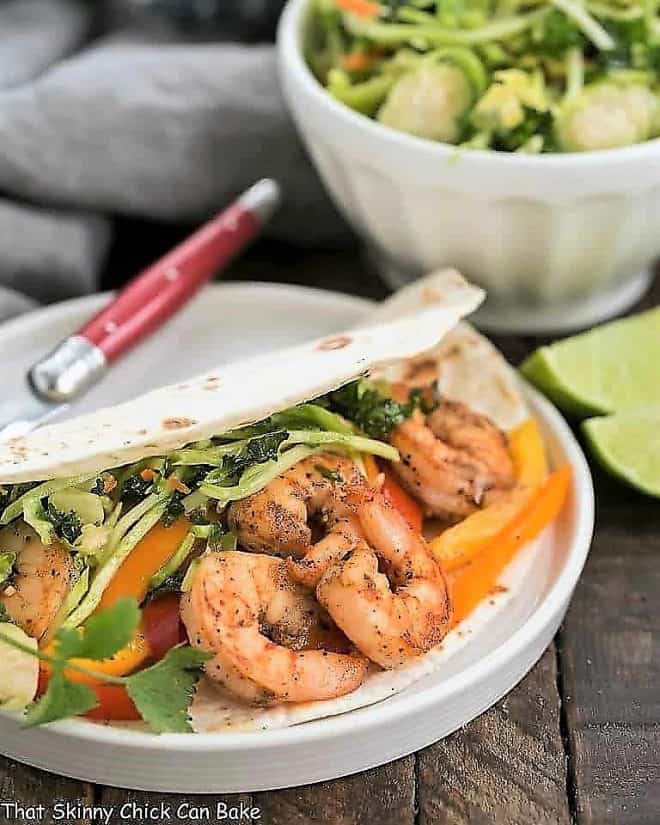 Easy Seafood Fajitas on a white plate with a red handled fork
