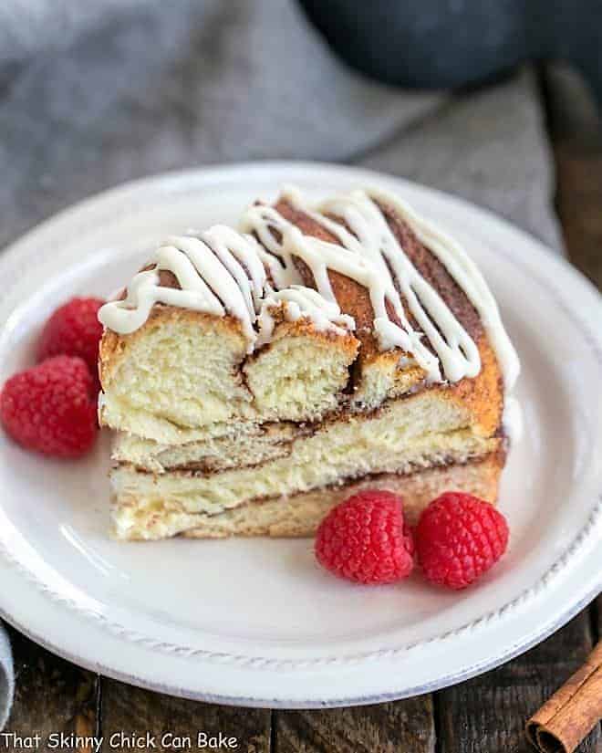 Cinnamon Twist Bread slice on a white plate with raspberries.