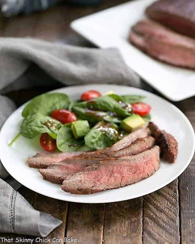 Red Wine, Soy, Balsamic Marinated Flank Steak on a white dinner plate.