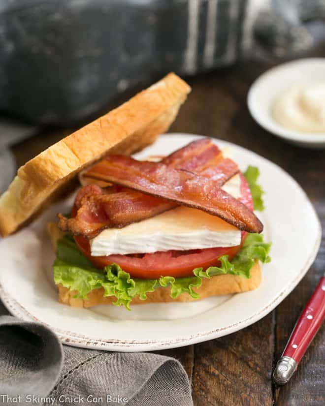 Upscale BLT Recipe - A BLT sandwich with creamy French Brie! Brie Bacon Lettuce and Tomato Sandwich on a white plate.