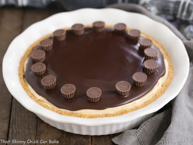 Frozen Chocolate Peanut Butter Pie in a white ceramic pie plate topped with mini Reese's cups.