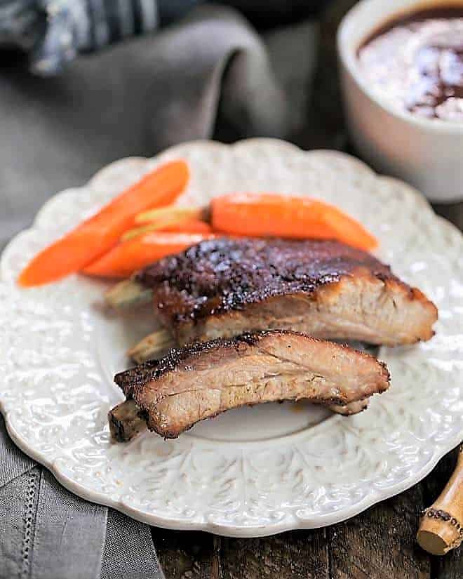 Instant Pot Baby Back Ribs on a white plate with carrots