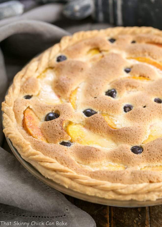 Peach Blueberry Custard Pie in a glass pie dish with a braided crust.