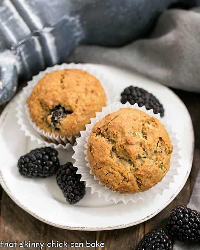 Blackberry Bran Muffins on a white plate garnished with berries