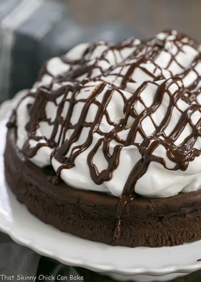 Flourless Chocolate Cake with Marshmallow Frosting on a white cake stand