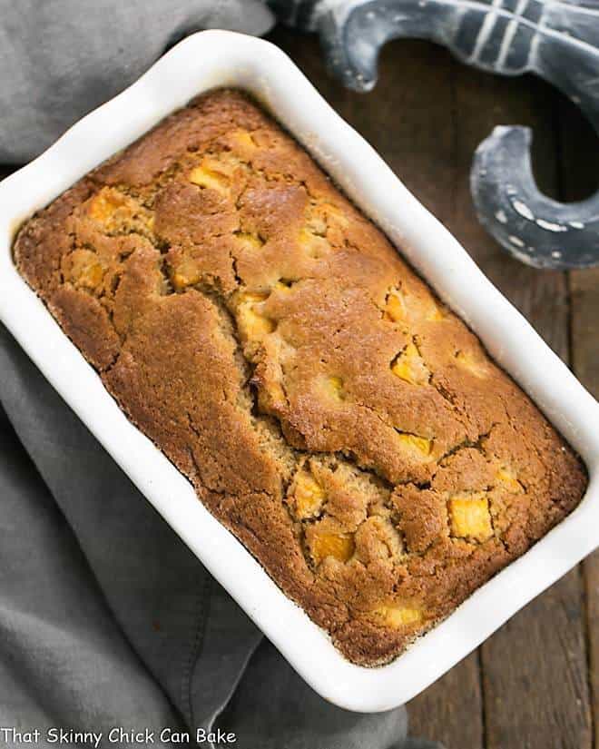 Fresh Southern Peach Bread in a white ceramic loaf pan.