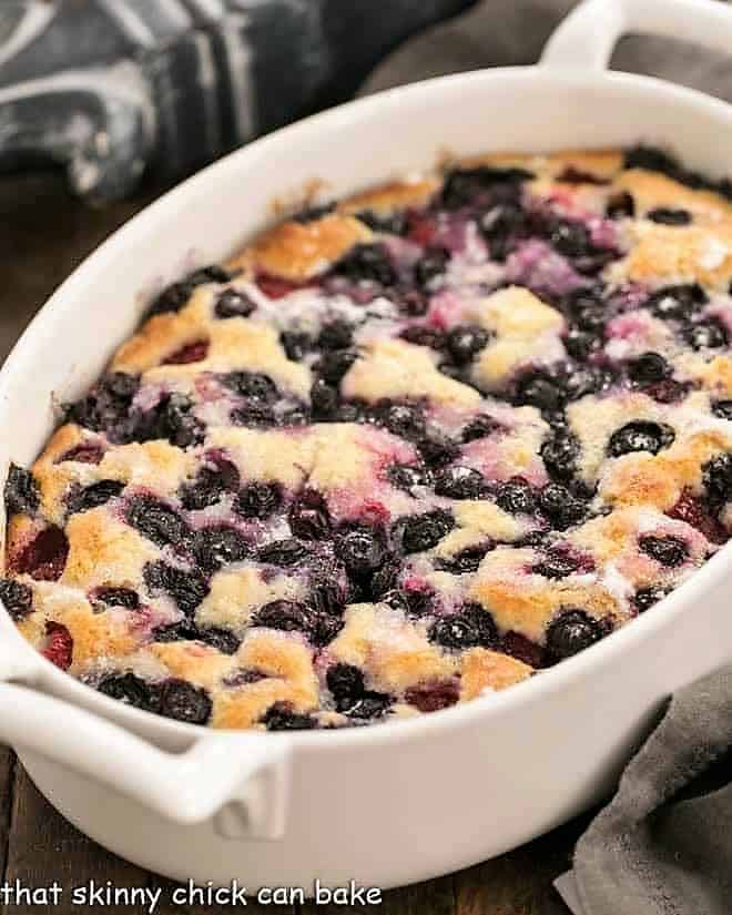 Mixed berry cobbler in a white, oval casserole.