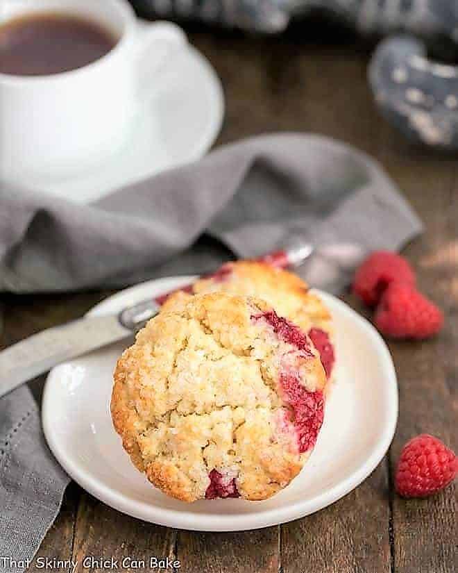 Raspberry Cream Scones on a round white plate with a cup of tea