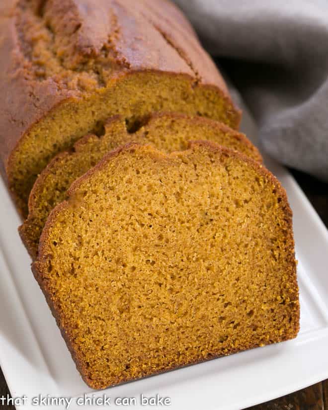 Classic Pumpkin Bread loaf and slices on a white tray.