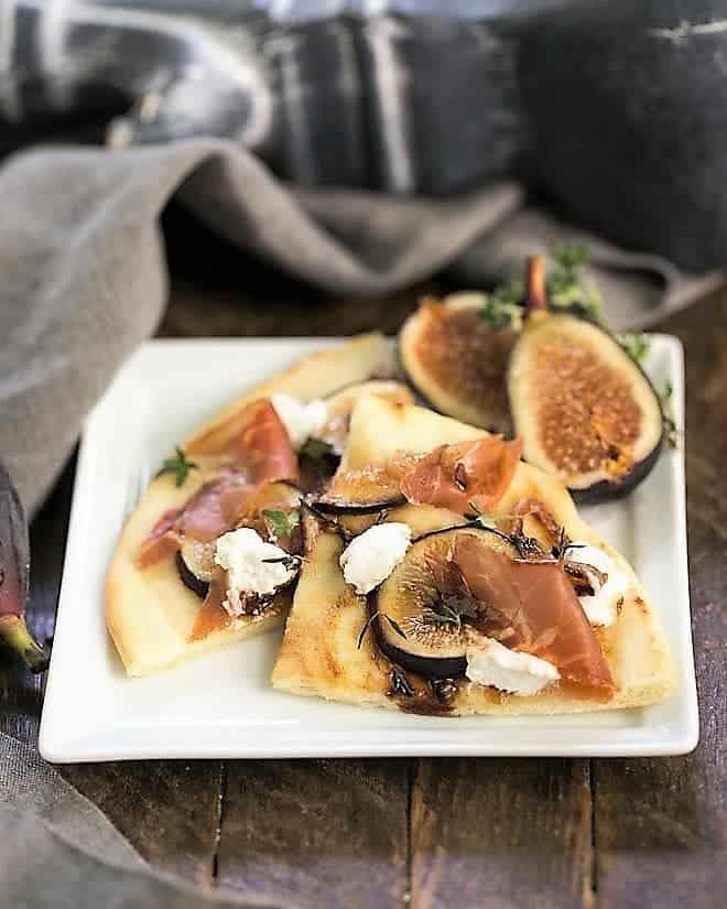 Fig, Goat Cheese and Prosciutto Pizza slices on a square white plate