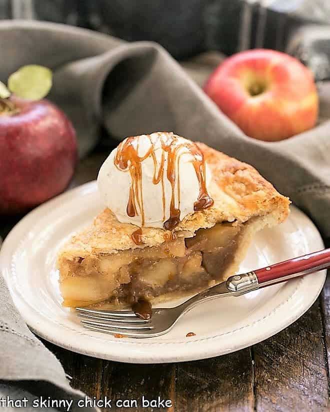 Slice of Caramel Apple Pie on a white plate with a red handled fork