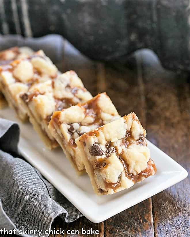 Chocolate Chip Caramel Butter Bars on a white ceramic tray.