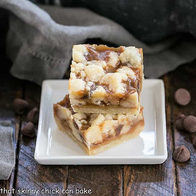 Two Chocolate Chip Caramel Butter Bars on a square white dish