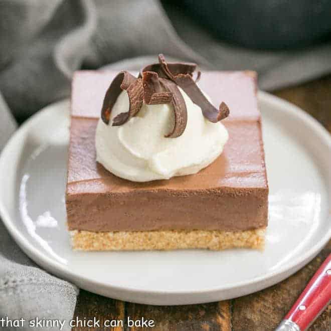 Easy chocolate mousse bars on a white plate with cream and chocolate shavings