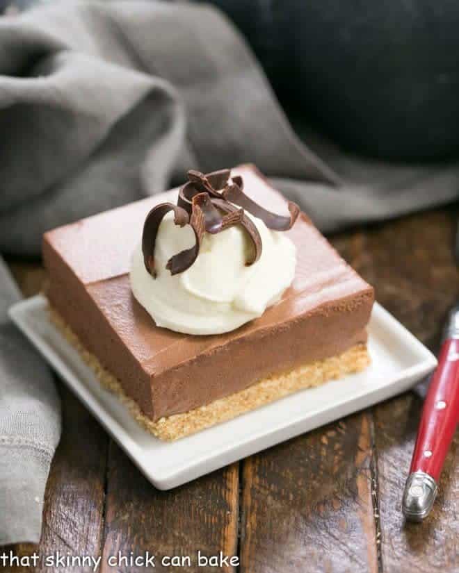 Easy chocolate mousse bars on a white plate with cream and chocolate shavings