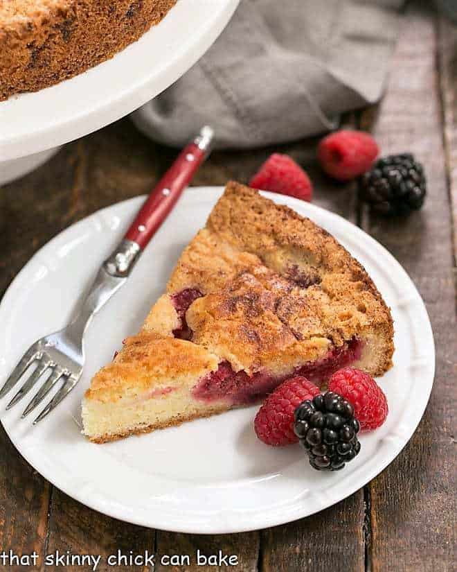 Mixed Berry Torte on a dessert plate with a fork and berries to garnish.