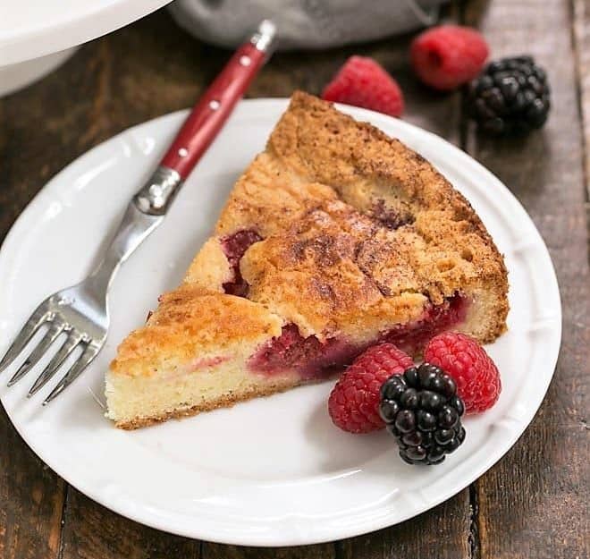 Mixed Berry Torte on a dessert plate with a fork and berries.