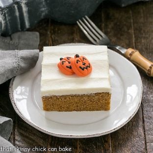 One pumpkin bar garnished with 2 candy pumpkins on a round white plate