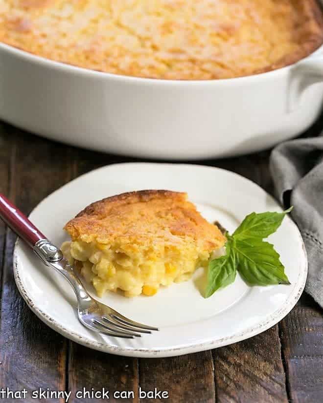 Easy Sweet Corn Casserole on a small white plate garnished with basil