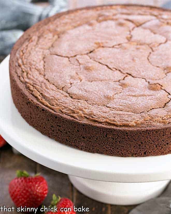 Italian Flourless Chocolate Cake on a white ceramic cake stand.