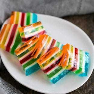 Slices of Jello Rainbow Ribbon Salad on a white oval dish