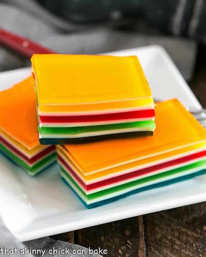 Jello Rainbow Ribbon Salad slices on a square white plate