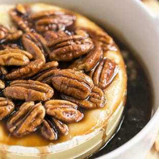 Kahlua Caramel Baked Brie in a round ceramic baking dish topped with pecans