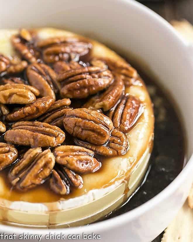 Kahlua Caramel Baked Brie in a round ceramic baking dish topped with pecans