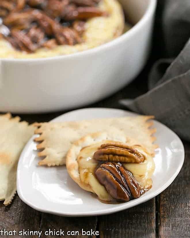 Kahlua Caramel Baked Brie on a cracker on a small white plate