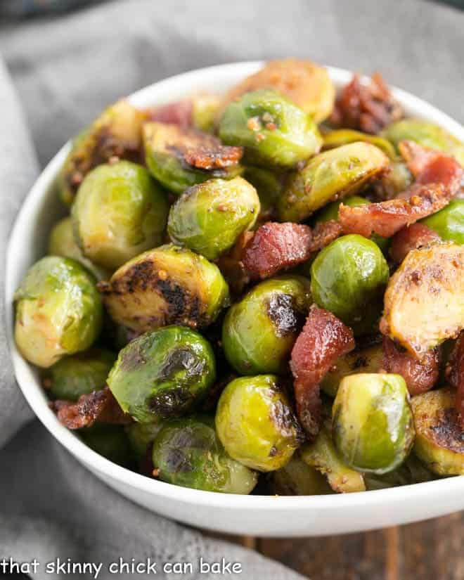 Maple Syrup Mustard Glazed Brussels Sprouts closeup in a white ceramic bowl.