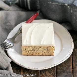 Sour Cream Banana Cake on a round white plate with a red handled fork
