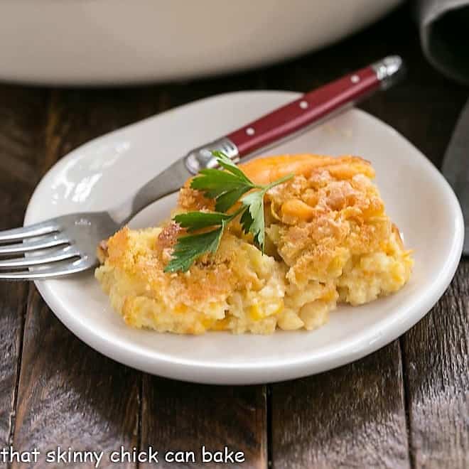 Scoop of Jiffy Corn Casserole on a small white plate with a red handled fork