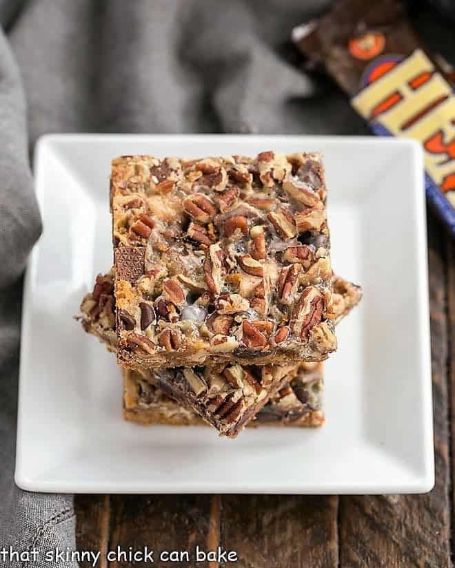Toffee Caramel Magic Cookie Bars stacked on a white plate