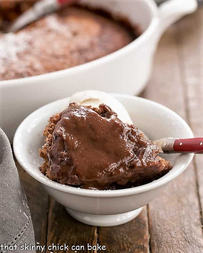 Easy Chocolate Pudding Cake - this Bisquick pudding cake is easy and bakes up into a soft cake layer and a fudgy sauce layer! Easy Chocolate Pudding Cake in a white bowl with a red handled fork.